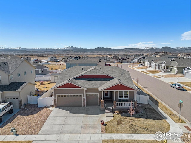 view of front of house featuring fence, a residential view, covered porch, a mountain view, and a gate