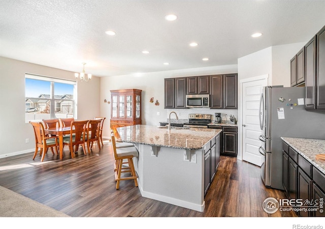 kitchen featuring a sink, dark wood-type flooring, a notable chandelier, and stainless steel appliances