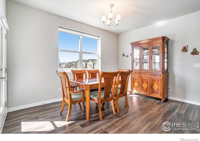 dining room with a chandelier, dark wood-style floors, and baseboards