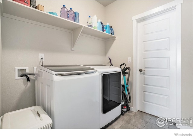 washroom with light tile patterned floors, washing machine and dryer, and laundry area