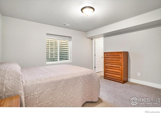 bedroom featuring visible vents, carpet floors, a textured ceiling, and baseboards