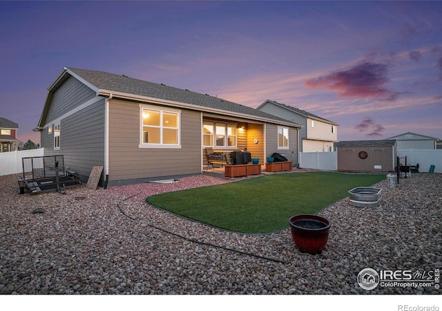 rear view of property with a fenced backyard, an outdoor structure, a patio area, outdoor lounge area, and a lawn