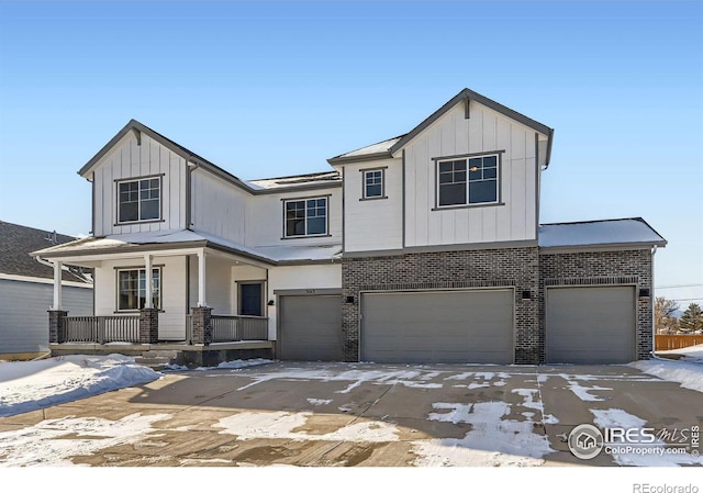 view of front of home with driveway, covered porch, board and batten siding, and an attached garage