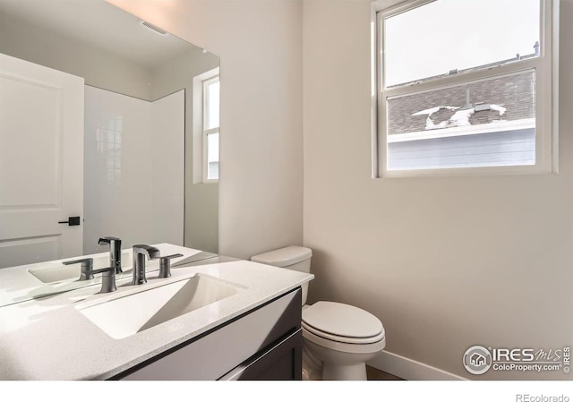 bathroom with visible vents, toilet, and vanity