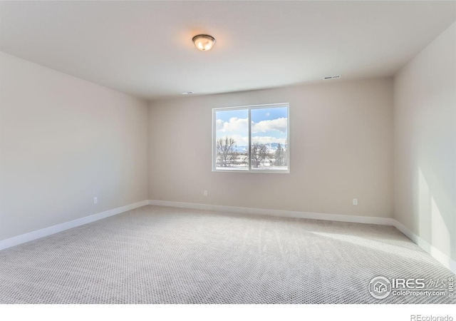 unfurnished room with baseboards, light carpet, and visible vents