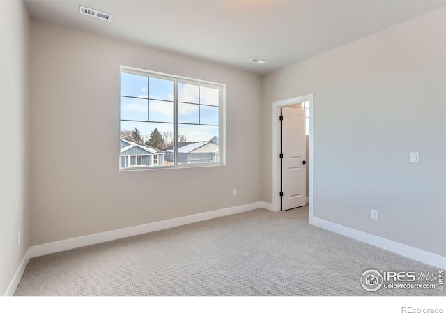 unfurnished room with visible vents, baseboards, and carpet