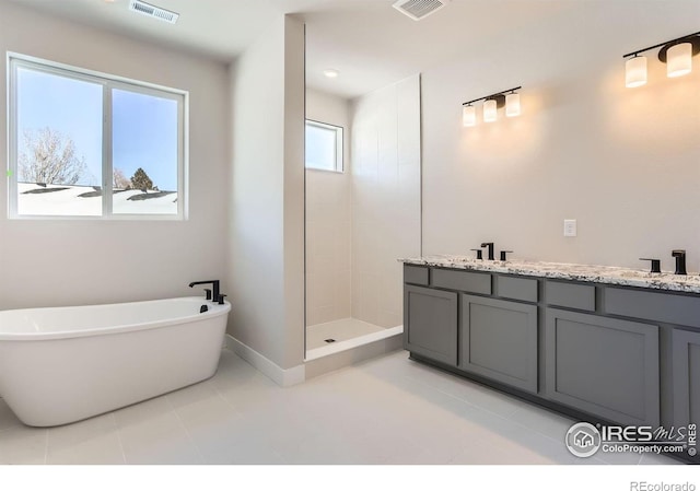 full bath with a sink, a soaking tub, visible vents, and tiled shower