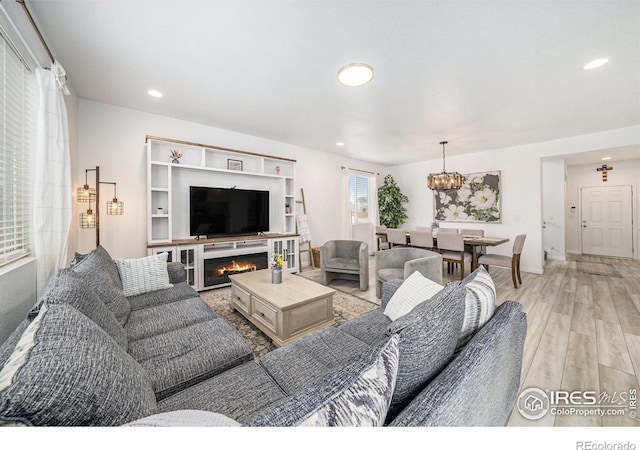 living room featuring recessed lighting, light wood-style flooring, and a chandelier