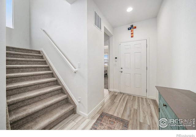 foyer entrance with visible vents, light wood-style flooring, recessed lighting, stairway, and baseboards