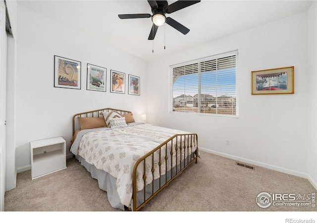 carpeted bedroom featuring a ceiling fan, baseboards, and visible vents