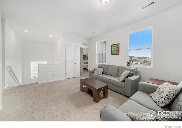 carpeted living area with recessed lighting, visible vents, and baseboards