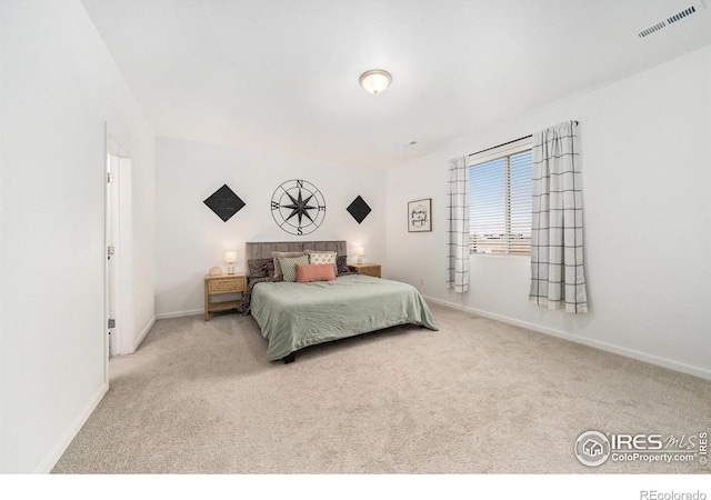 carpeted bedroom with visible vents and baseboards