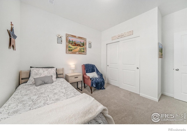 carpeted bedroom featuring a closet, baseboards, and visible vents