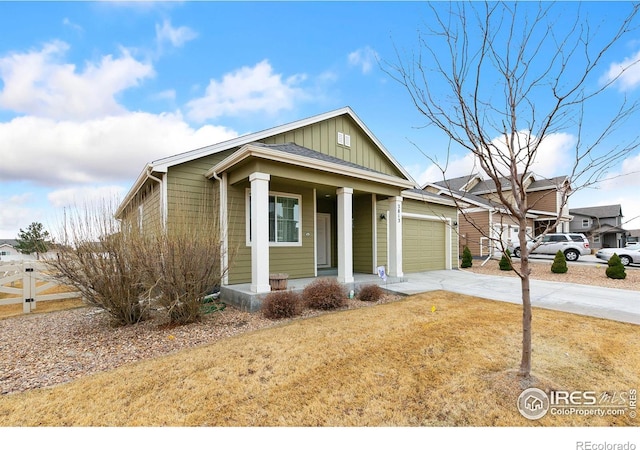 view of front of home featuring board and batten siding, an attached garage, a porch, and driveway