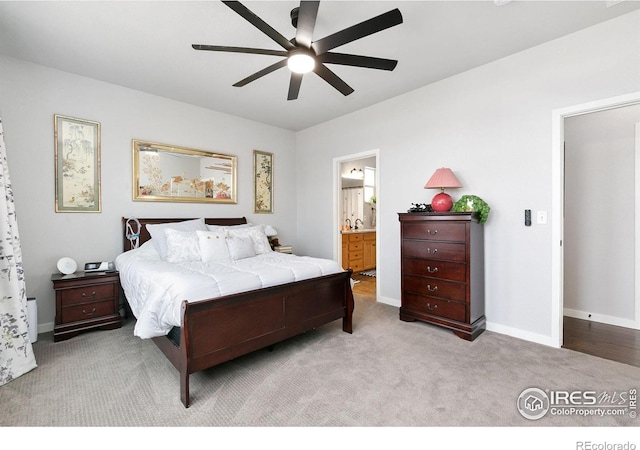 carpeted bedroom featuring baseboards, a ceiling fan, and ensuite bathroom