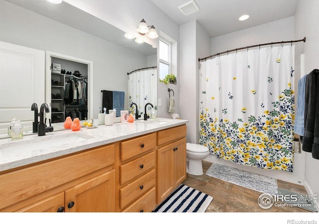 full bathroom featuring double vanity, toilet, visible vents, and a sink