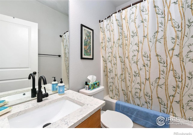 bathroom with shower / tub combo with curtain, toilet, vanity, and a textured wall