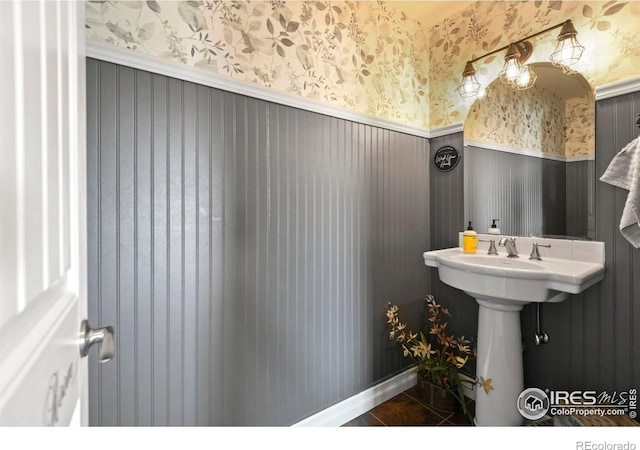 bathroom with a wainscoted wall, tile patterned flooring, and wallpapered walls