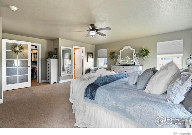 carpeted bedroom featuring a textured ceiling, a closet, a spacious closet, and connected bathroom