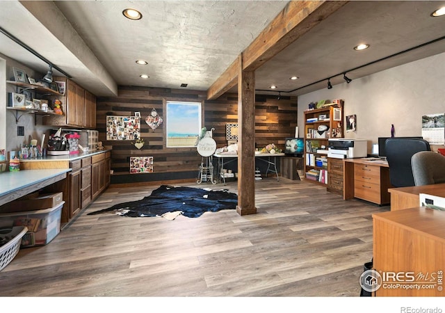 office with wood walls, light wood-type flooring, and recessed lighting
