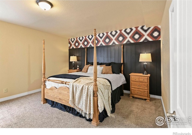 carpeted bedroom featuring a textured ceiling and baseboards