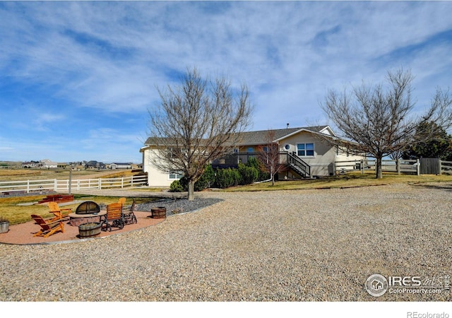 view of front of home with an outdoor fire pit, a deck, fence, and stairway