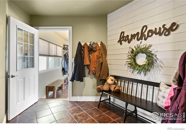 33409 Faith Ln, Eaton, CO 80615 - mudroom with dark tile patterned flooring and wooden walls