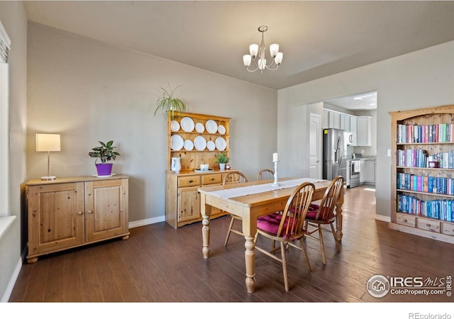 dining room featuring a chandelier, dark wood finished floors, and baseboards