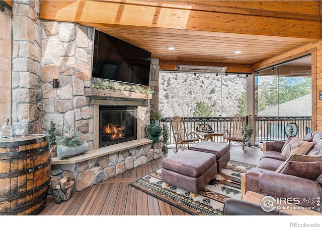 9512 County Road 43, Glen Haven, CO 80532 - living area featuring a stone fireplace, beamed ceiling, wood ceiling, and wood finished floors