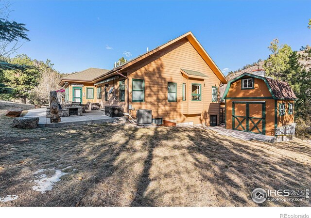9512 County Road 43, Glen Haven, CO 80532 - back of property with an outbuilding, a patio, a fire pit, a storage shed, and central AC unit