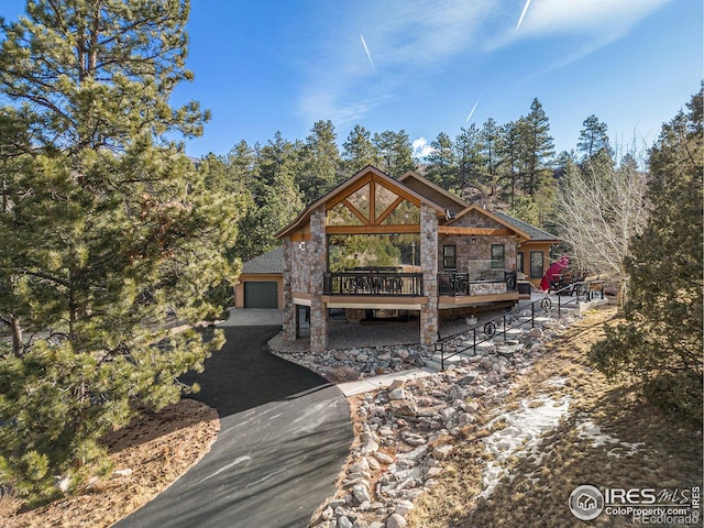 9512 County Road 43, Glen Haven, CO 80532 - back of property featuring aphalt driveway, stone siding, and a wooden deck