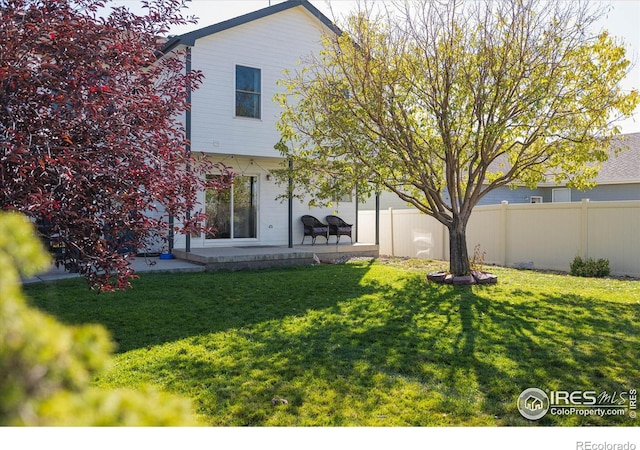 back of house with a patio, a yard, and fence
