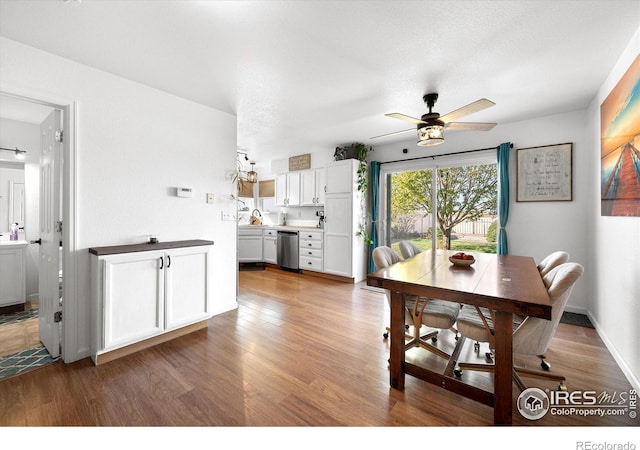dining space with a ceiling fan, wood finished floors, and baseboards
