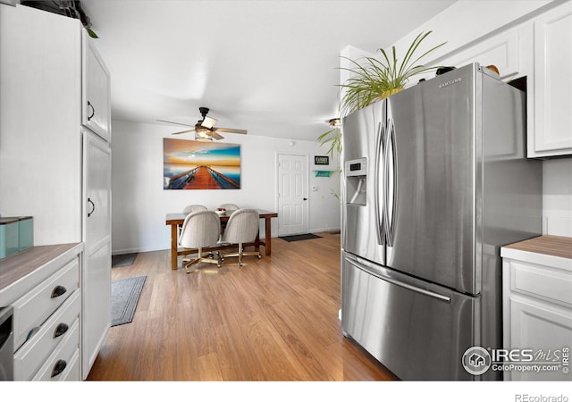 kitchen with a ceiling fan, baseboards, light wood finished floors, white cabinets, and stainless steel refrigerator with ice dispenser