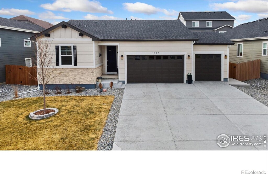 view of front of house featuring an attached garage, driveway, roof with shingles, and fence