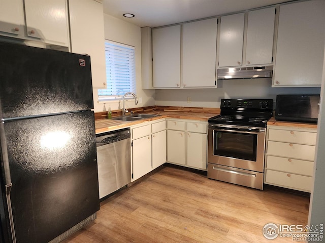 1512 12th Ave Unit 1, Greeley, CO 80631 - kitchen featuring appliances with stainless steel finishes, under cabinet range hood, wood counters, and light wood finished floors