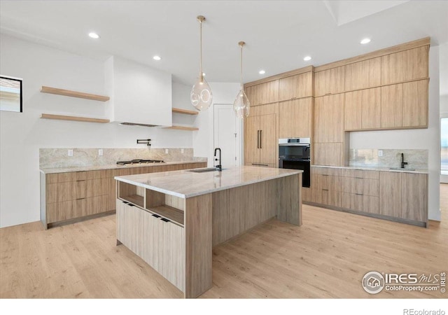kitchen featuring open shelves, modern cabinets, a sink, light wood finished floors, and recessed lighting