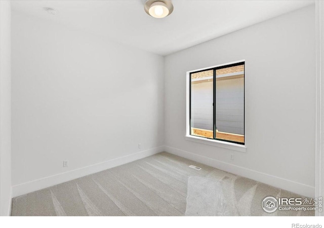 empty room featuring carpet floors and baseboards