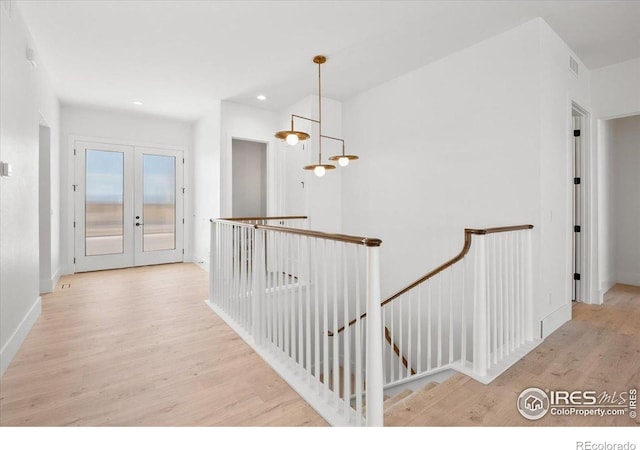 corridor with an upstairs landing, wood finished floors, french doors, recessed lighting, and baseboards