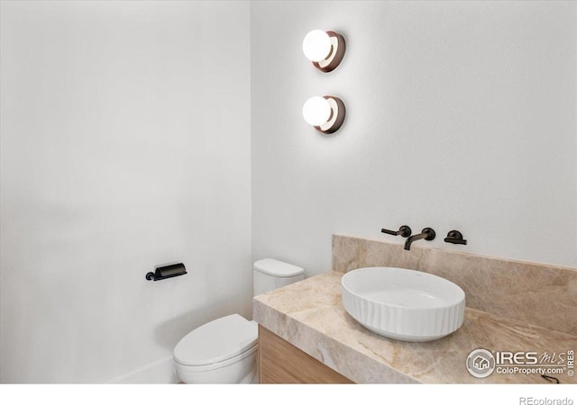 half bath featuring toilet and vanity