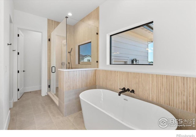 full bath with a shower stall, a soaking tub, and tile patterned floors