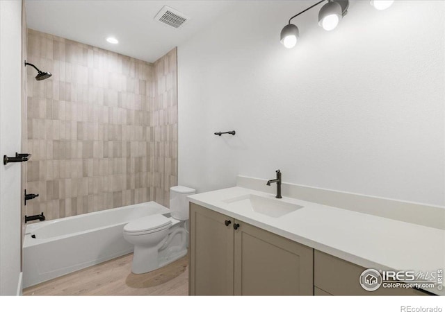 full bath with wood finished floors, toilet, bathing tub / shower combination, and vanity