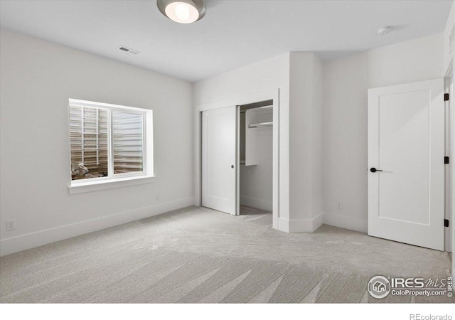 unfurnished bedroom with carpet floors, baseboards, and a closet