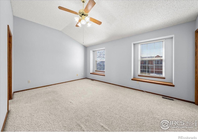 660 Fernglen Ct, Colorado Springs, CO 80906 - carpeted empty room with visible vents, lofted ceiling, a textured ceiling, baseboards, and ceiling fan