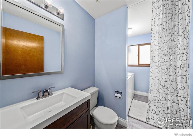660 Fernglen Ct, Colorado Springs, CO 80906 - bathroom with baseboards, toilet, wood finished floors, and vanity