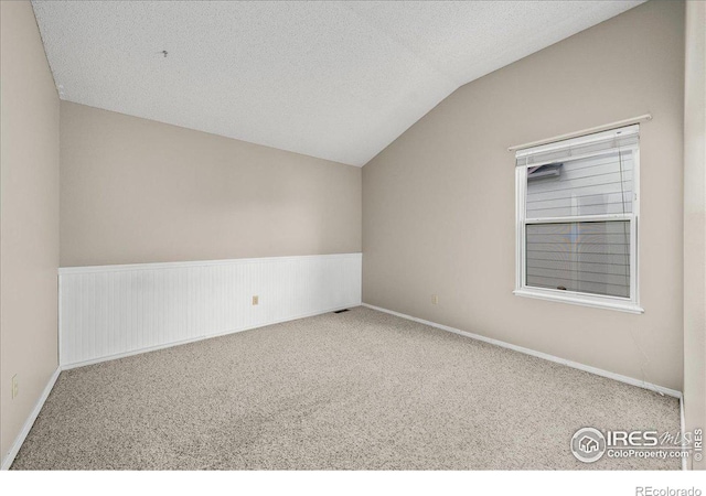 660 Fernglen Ct, Colorado Springs, CO 80906 - empty room with lofted ceiling, carpet, and a textured ceiling