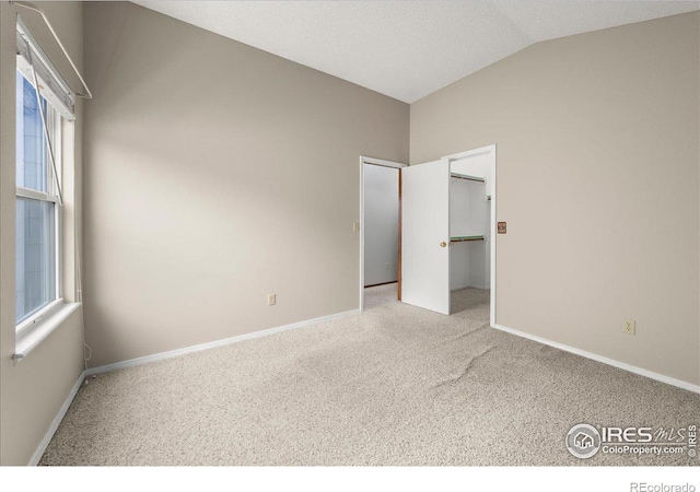 660 Fernglen Ct, Colorado Springs, CO 80906 - unfurnished bedroom featuring a spacious closet, baseboards, carpet, and vaulted ceiling