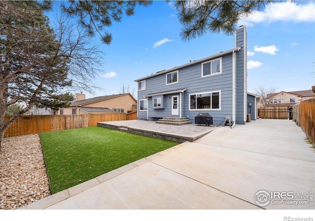 660 Fernglen Ct, Colorado Springs, CO 80906 - back of house with a yard, a fenced backyard, a chimney, and a patio