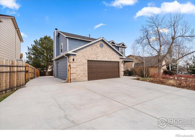 660 Fernglen Ct, Colorado Springs, CO 80906 - view of home's exterior featuring brick siding, fence, a chimney, a garage, and driveway