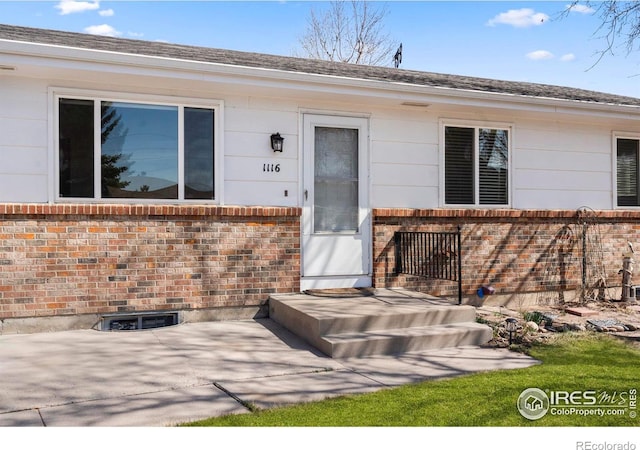 property entrance featuring brick siding